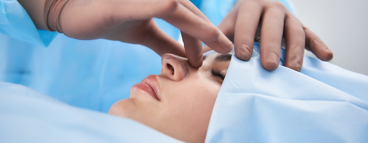 attachment-surgeon-in-rubber-gloves-making-rhinoplasty-for-woman-picture-id1131127082