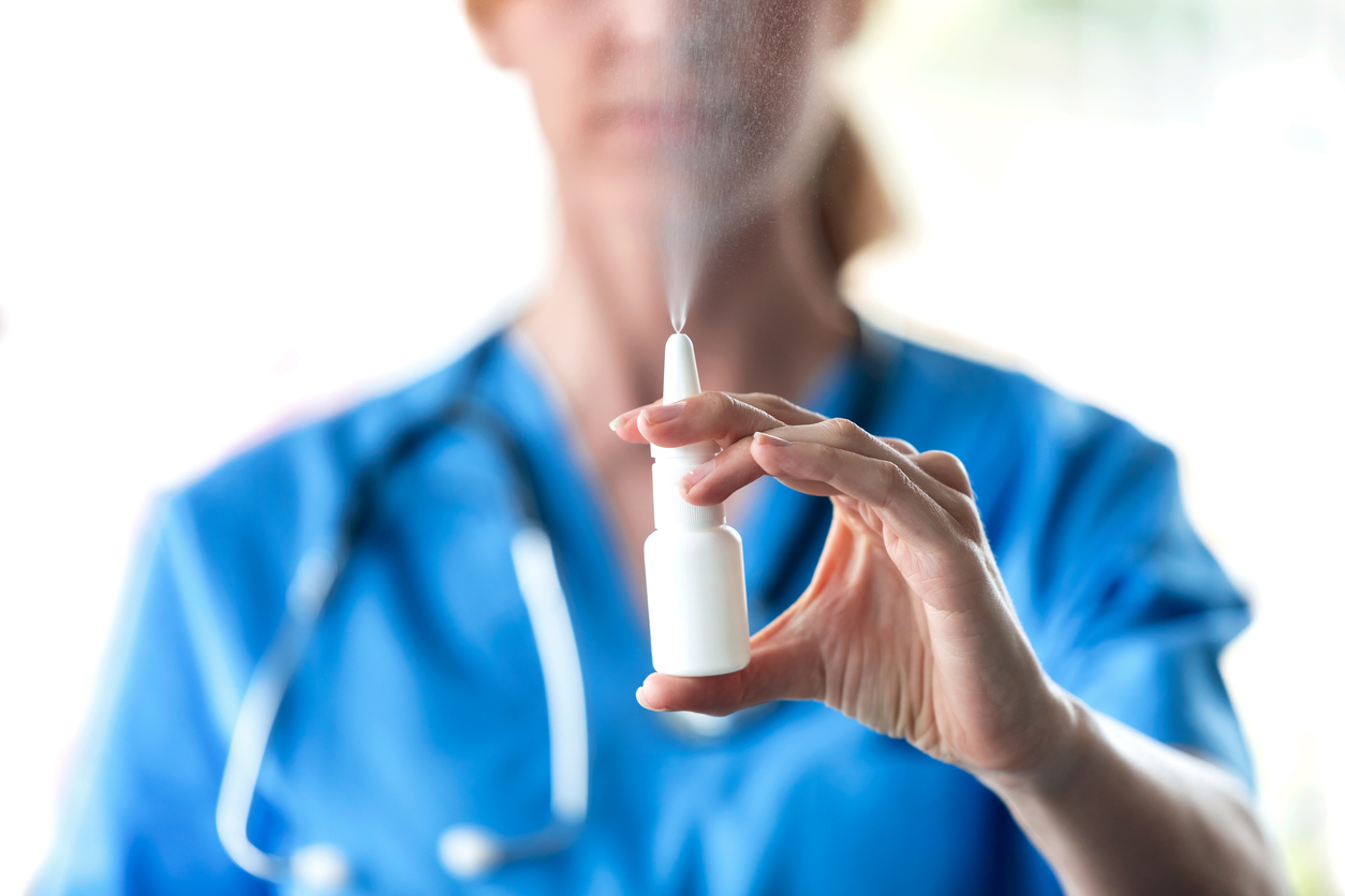 female-doctor-with-a-spray-or-nasal-drops-for-the-treatment-of-a-runny-nose-over-white-background