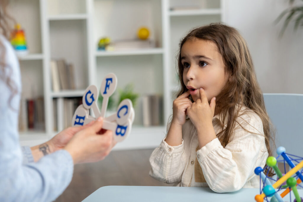 speech-therapist-showing-letters-to-a-girl-while-having-a-training-session
